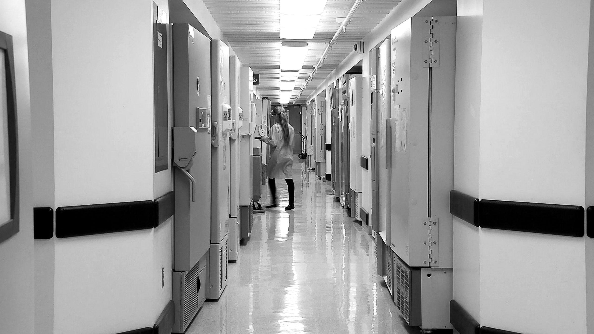 A long hospital corridor lined with storage cabinets